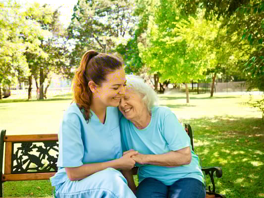 Staff member sharing a joyful moment with a resident outdoors