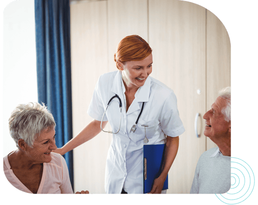 Nurse interacting with two smiling residents