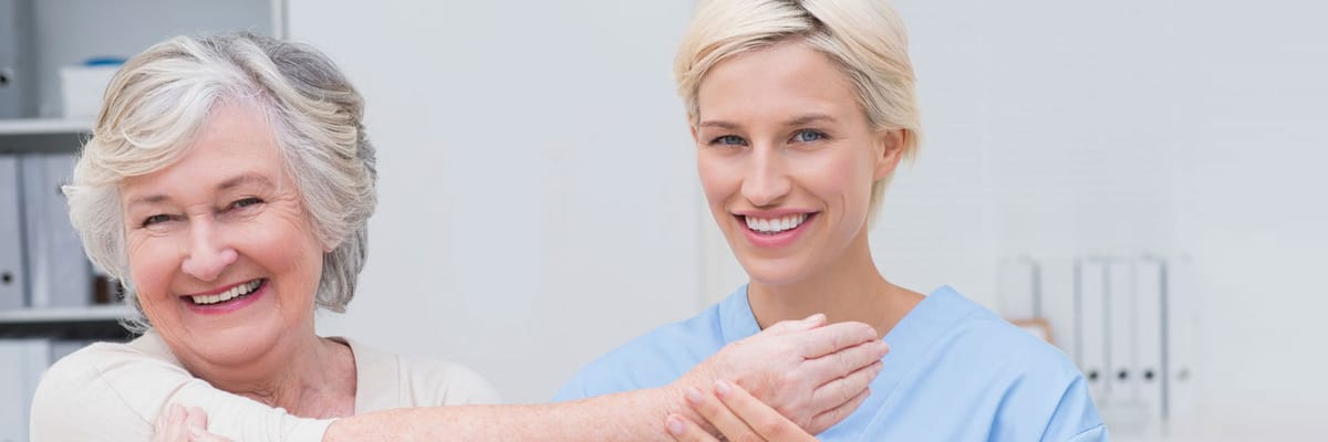 Smiling resident with a caregiver in a bright room