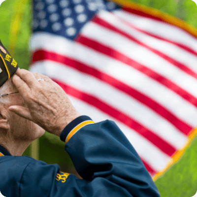 Senior veteran saluting in front of an American flag