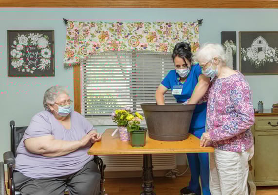Residents participating in a gardening activity with staff
