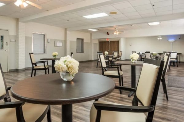 Bright common area with tables and floral centerpieces