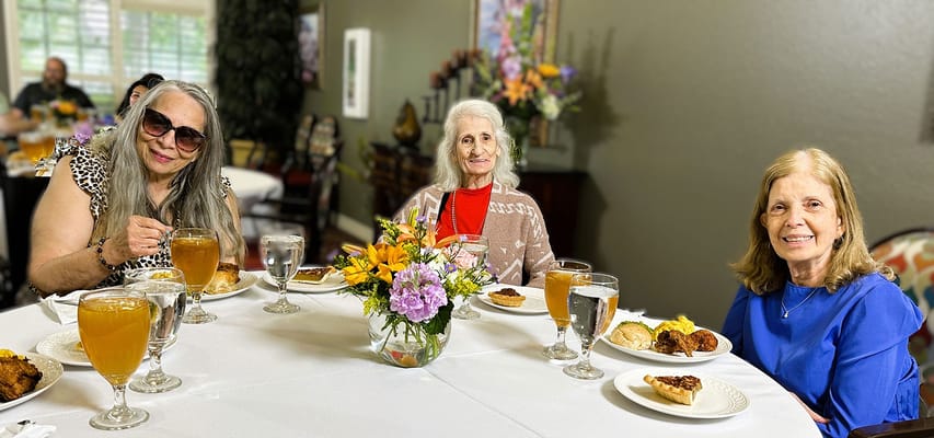 Three residents enjoying a meal in the dining area
