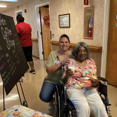 Employee with a resident in a hallway holding ice cream