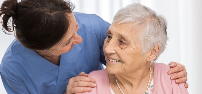 Caregiver interacting warmly with an elderly resident