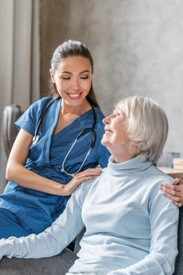 Caregiver smiling with an elderly resident in a cozy setting