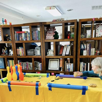 Resident participating in a bowling activity in a common area