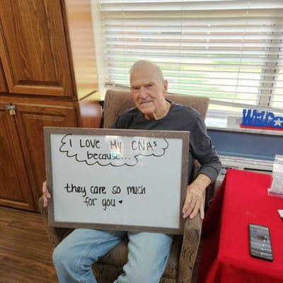 Senior resident holding a sign expressing gratitude