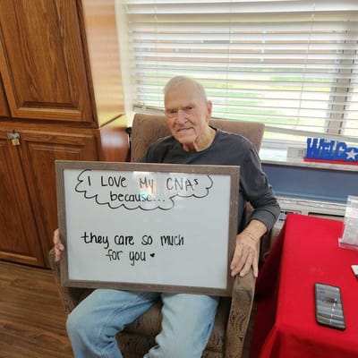 Senior resident holding a sign expressing gratitude