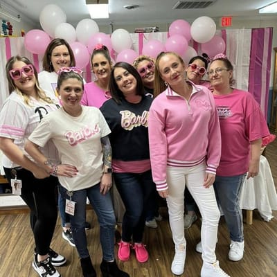 Staff members celebrating in a decorated activity room