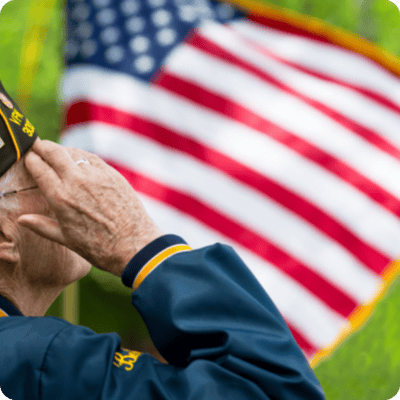 A veteran saluting in front of an American flag