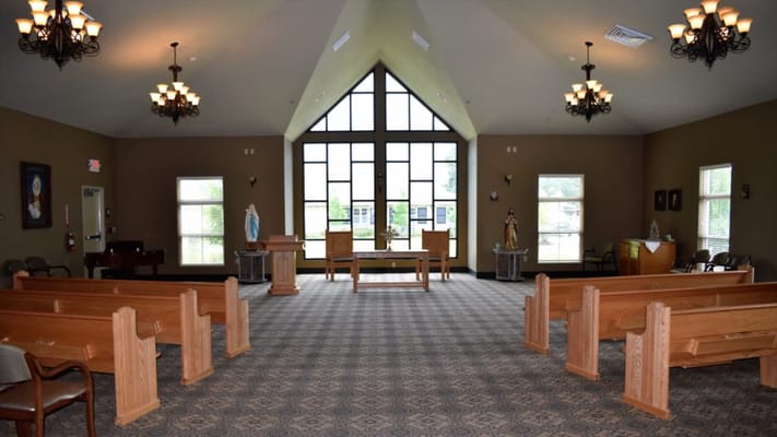 Interior view of a chapel with wooden pews