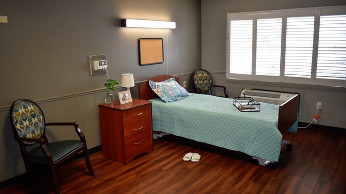 Well-furnished private resident room with a bed and seating