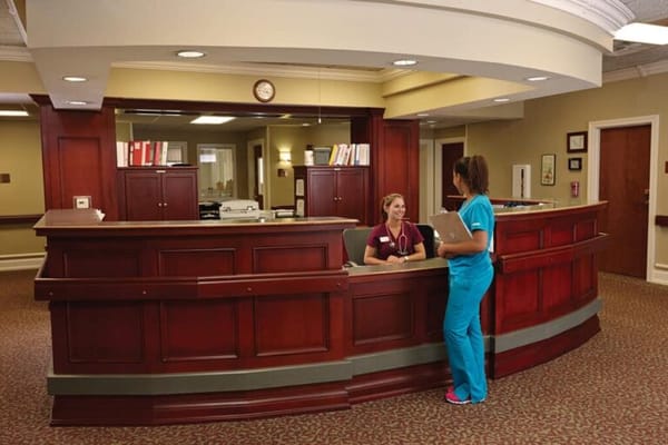 Staff member assisting a resident at the reception desk