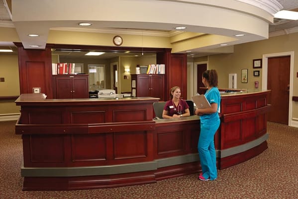 Staff member assisting a resident at the reception desk