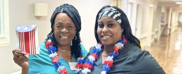 Two staff members celebrating with festive decorations