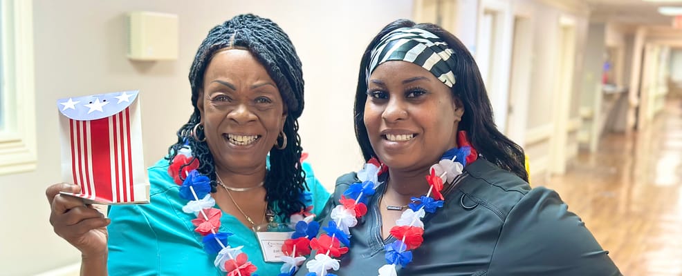 Two staff members celebrating with festive decorations