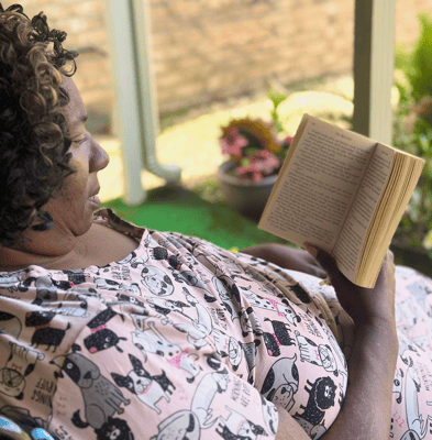 Resident enjoying a book on a porch