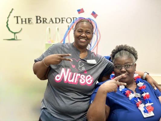 Two smiling staff members celebrating at the facility