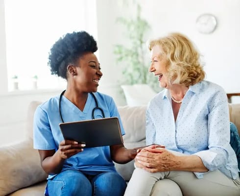 Caregiver interacting joyfully with a resident indoors