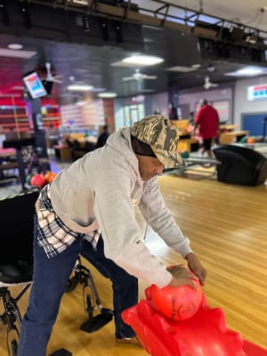 Resident bowling in an activity room