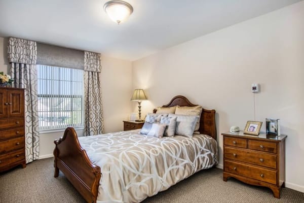 Cozy private bedroom with wooden furniture and window