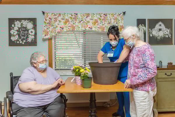 Residents participating in a gardening activity with staff