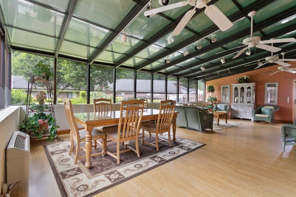 Bright sunroom with wooden furniture and green plants