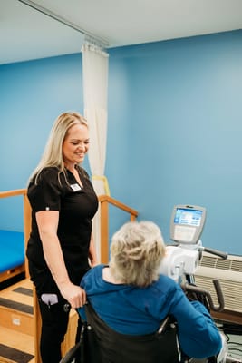 Staff assisting a resident with therapy equipment