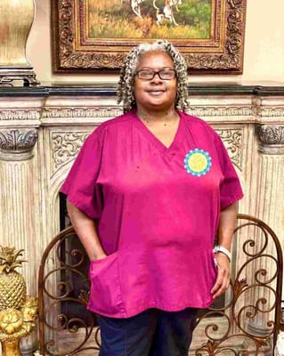 Staff member in a maroon uniform with a badge
