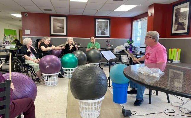 Residents participating in a music activity with large exercise balls