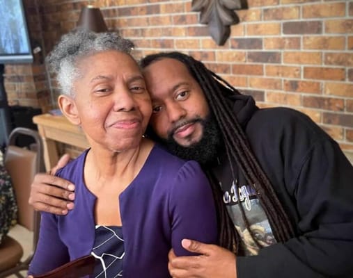 A resident and a visitor sharing a warm moment indoors
