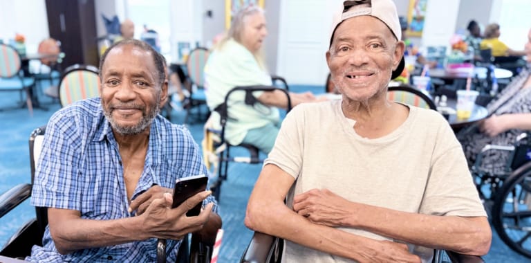 Two residents smiling in a lively common area