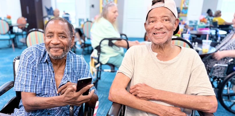 Two residents smiling in a lively common area