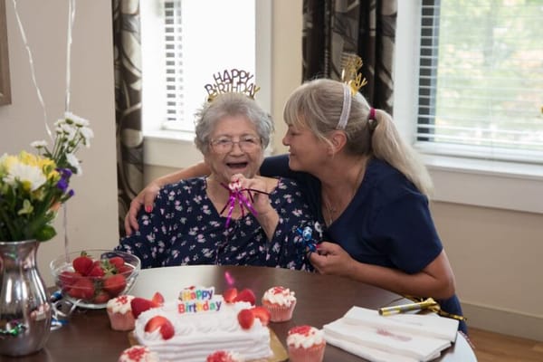 Residents celebrating a birthday with cake and laughter