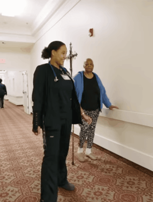 Staff member walking with a resident in the hallway