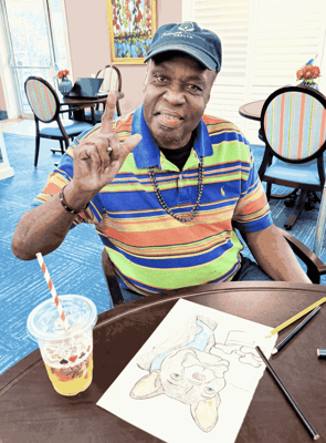 Resident engaging in an art activity with a drink