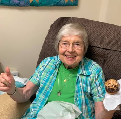 Resident enjoying a treat in a cozy chair