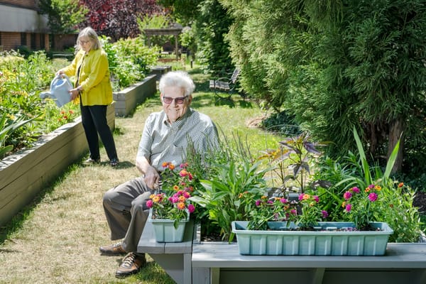 Senior resident enjoying a garden with flowers