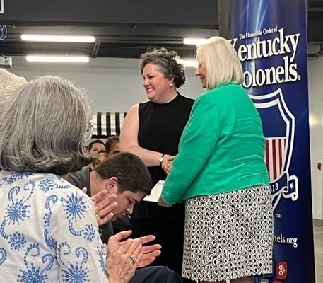 Residents and staff celebrating recognition awards in a communal space
