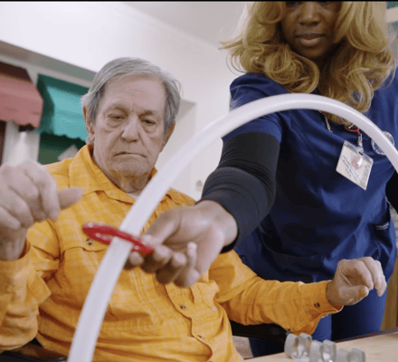 Staff assisting a resident with an activity