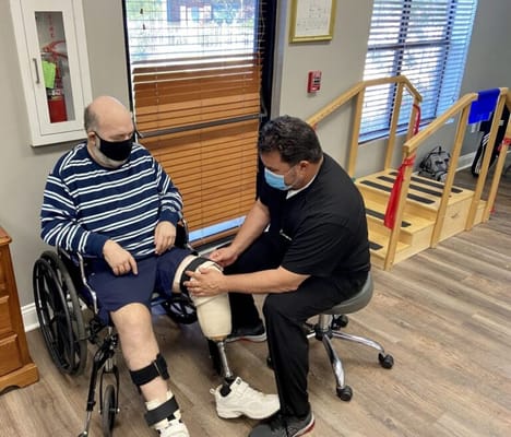 Staff assisting a resident with therapy in an interior space