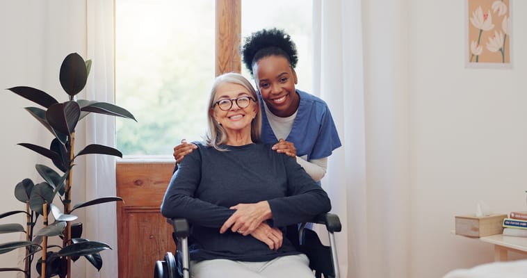 A caregiver with a smiling resident in a cozy room