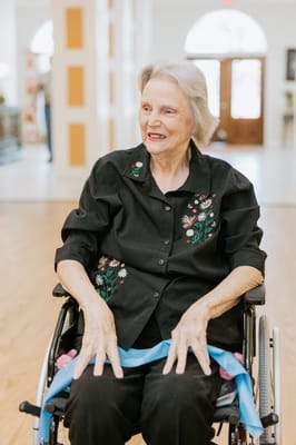 Senior woman in a wheelchair with flowers on her shirt