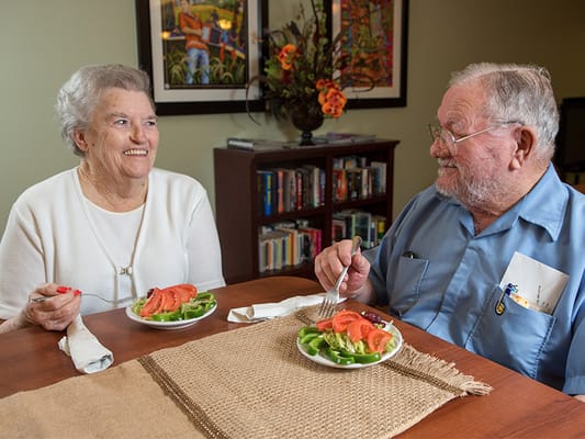 Two residents enjoying a meal in a dining area