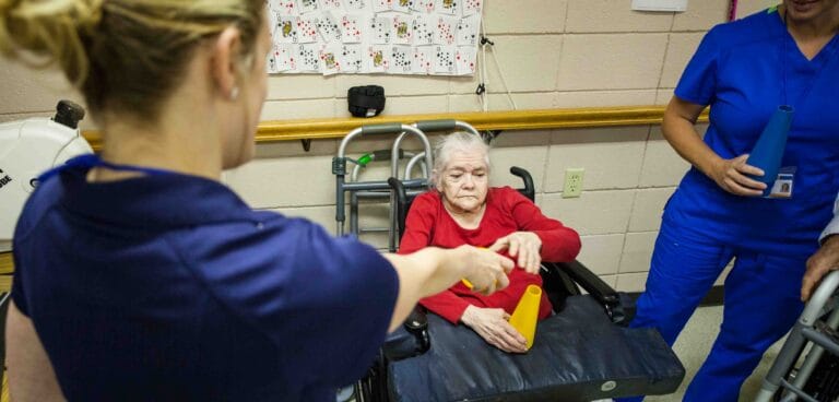 Residents participating in a hands-on activity with staff assistance