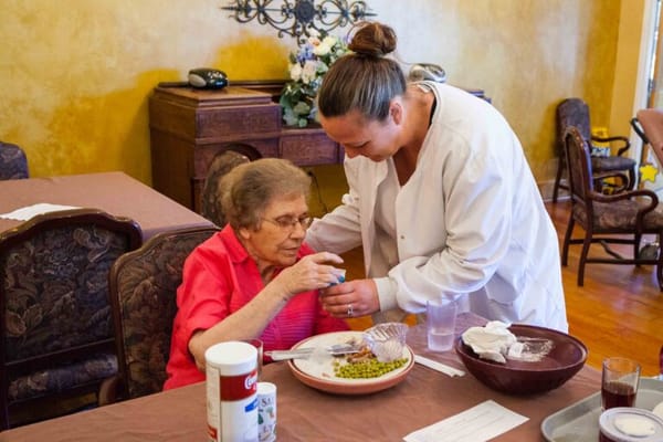 Caregiver assisting a resident during meal service