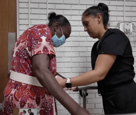 Staff assisting a resident in a wellness activity