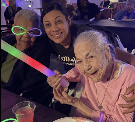 Residents and staff celebrating with glow sticks during an activity