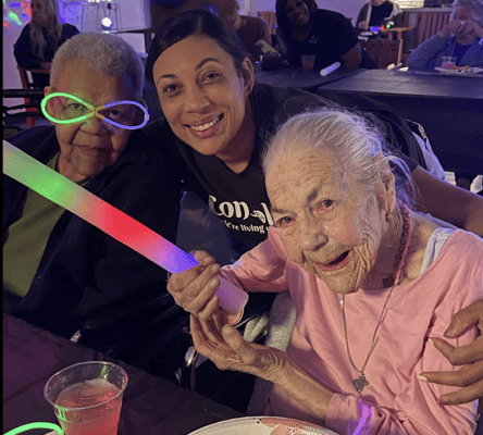 Residents and staff celebrating with glow sticks during an activity